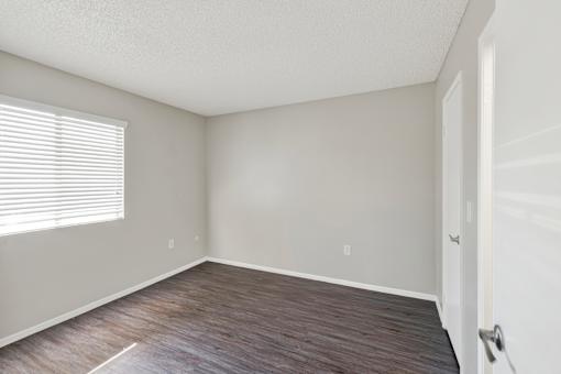 A room with a wooden floor and a white door.