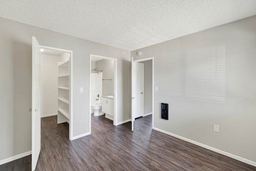 A room with a white door and a white bathroom with a toilet and sink.