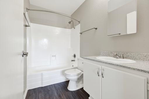 A white bathroom with a toilet, sink, and a shower.