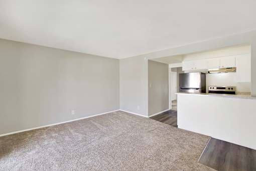 A spacious living room with a kitchenette in the corner.