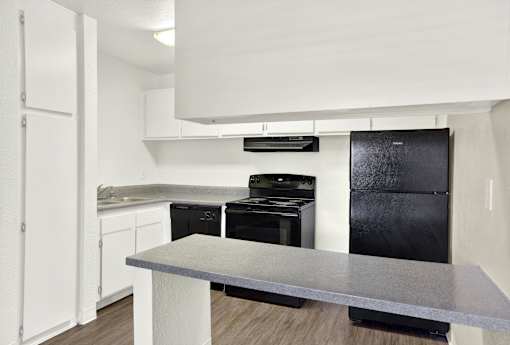 a kitchen with white cabinets and granite counter tops and a stove and sink