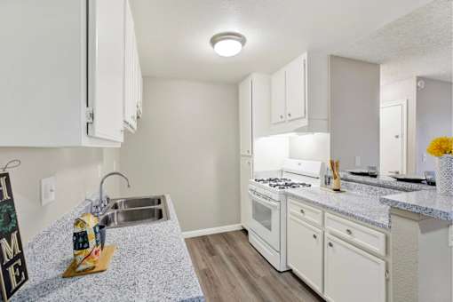 Modern kitchen with white appliances and granite countertops at ELEVATE Apartments HOMES, California, 92870