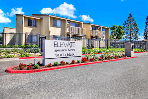 Property entrance sign with landscaping at ELEVATE Apartments HOMES, California