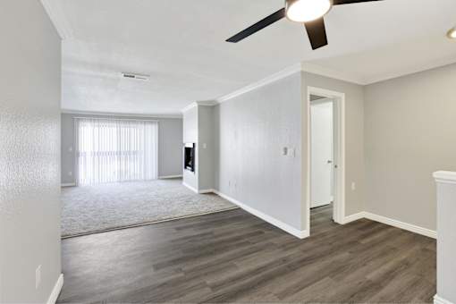 A room with a ceiling fan and light, a window with curtains, and a door at THE STREAMS Apartments, Apartments, Fullerton, CA