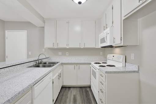 A kitchen with white cabinets and appliances at THE STREAMS Apartments, Fullerton, CA, 92831