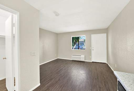 A room with a window and a picture on the wall.
