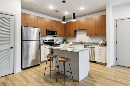 a kitchen with a island and two stools at Gibson Oaks, Lakeland, 33809