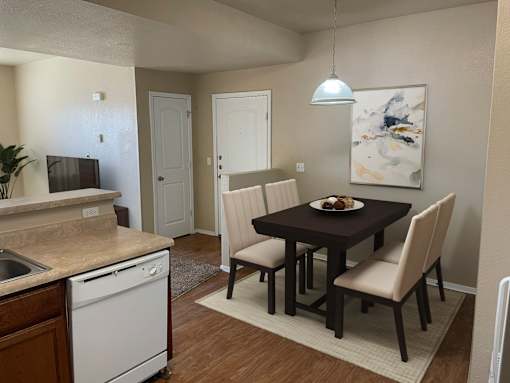 A kitchen with a dining table and chairs.
