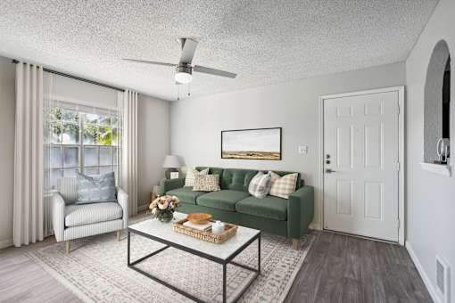 A living room with a green couch and a white chair.