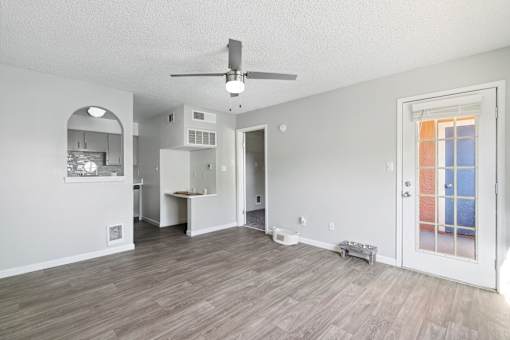 A room with a ceiling fan and a door leading to a balcony.