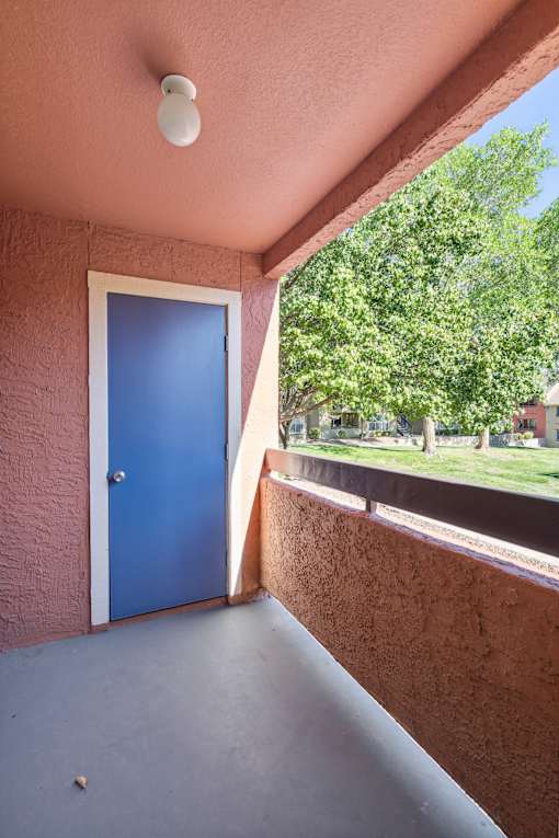 A blue door is on the left side of a concrete wall.
