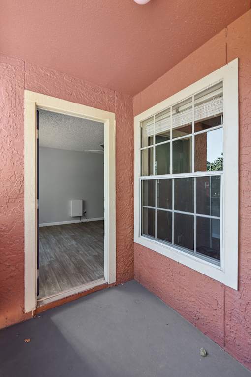 A room with a window and a door leading to another room.