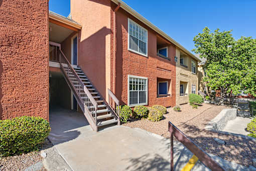 A red brick building with a staircase leading to the entrance.
