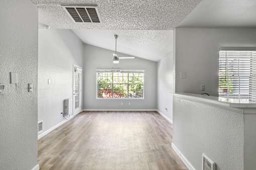 A spacious room with a window overlooking a garden.