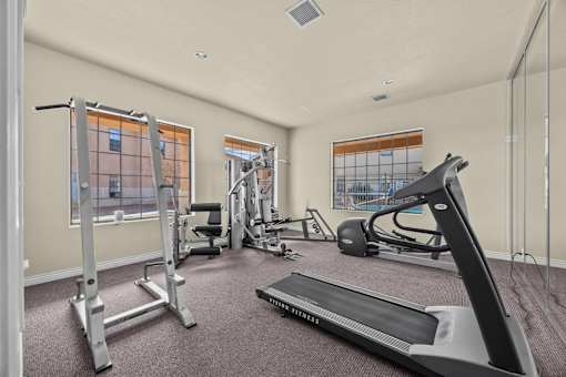 A spacious gym with a variety of equipment including treadmills, weights, and exercise machines.