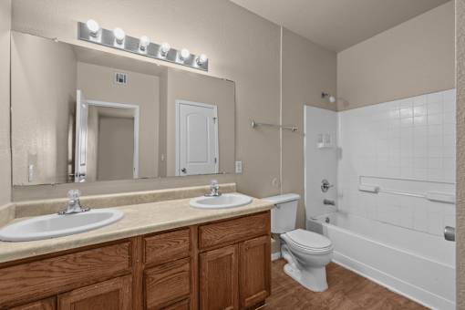 A bathroom with a white toilet and a white bathtub.