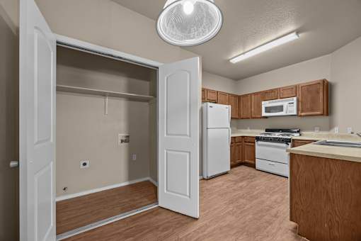 A kitchen with a refrigerator, microwave, and oven.