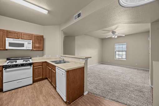 A kitchen with a white stove and a white dishwasher.