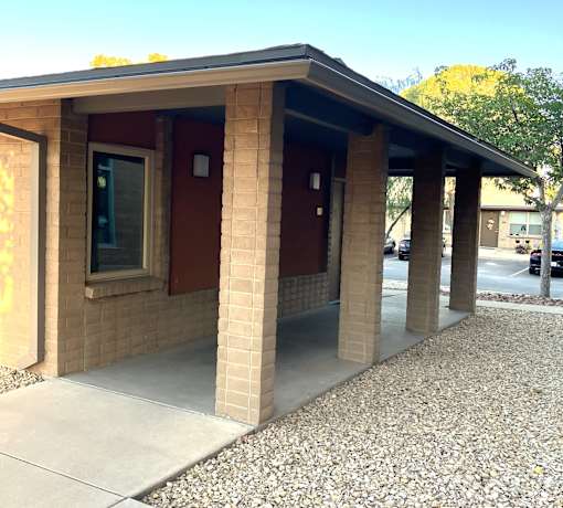 A small building with a red door and a brown roof.