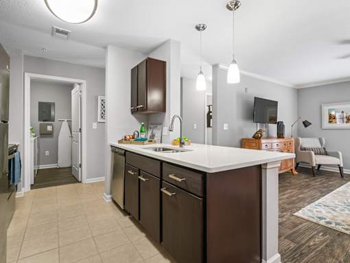 A modern kitchen with dark brown cabinets and a white countertop.