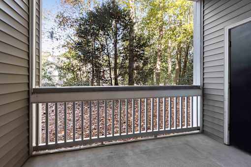 A view from a balcony looking out at a forest of trees.