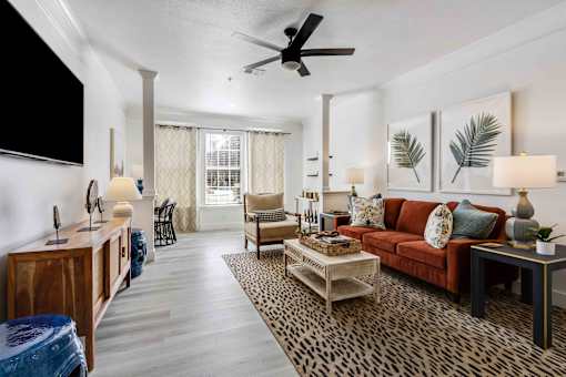 A living room with a leopard print rug and a red couch.