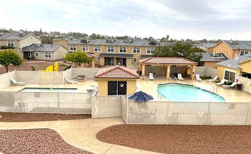 A backyard with a pool and a patio.