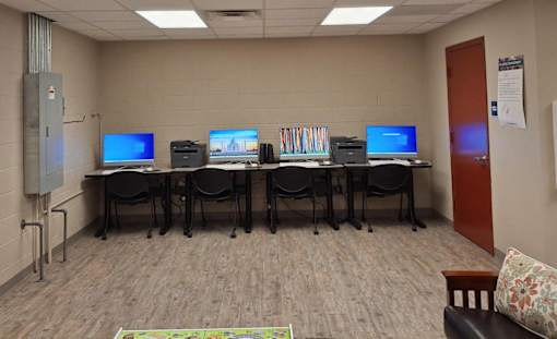 A room with computers and chairs.