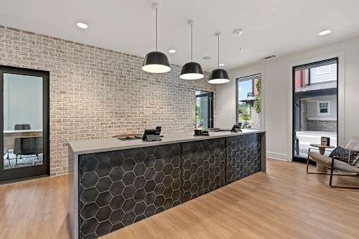 A reception area with a brick wall and a black and white reception desk.