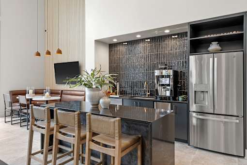 A modern kitchen with a bar area and stainless steel appliances.