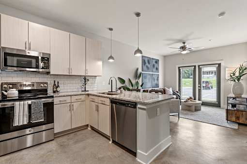 A modern kitchen with a large island and stainless steel appliances.