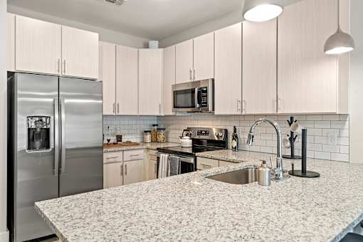 A kitchen with a granite countertop and a refrigerator.