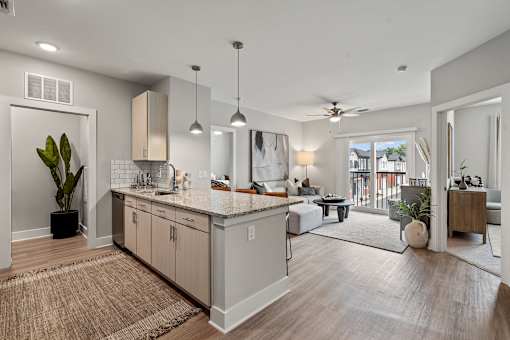 A modern kitchen with a large island and a dining area in the background.