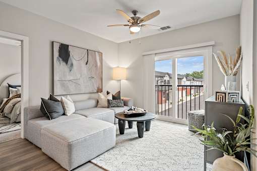 A living room with a grey couch, a coffee table, and a painting on the wall.