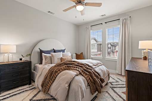 A bedroom with a large bed and a ceiling fan.