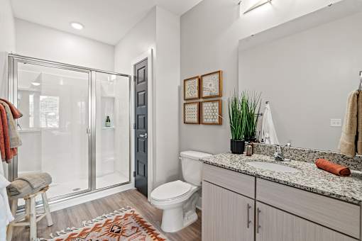 A bathroom with a toilet, sink, and shower.