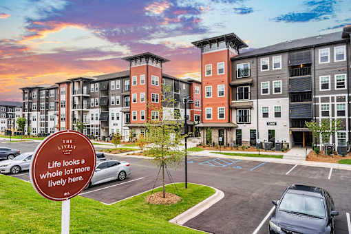 A sign in front of a parking lot says "The Life's a whole lot a lively here.".