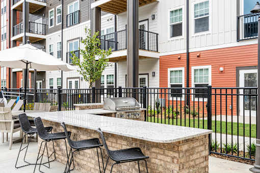 A patio with a bar and chairs in front of a building.