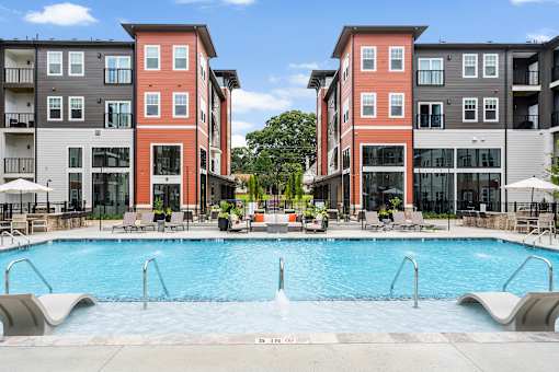 A swimming pool in front of apartment buildings.