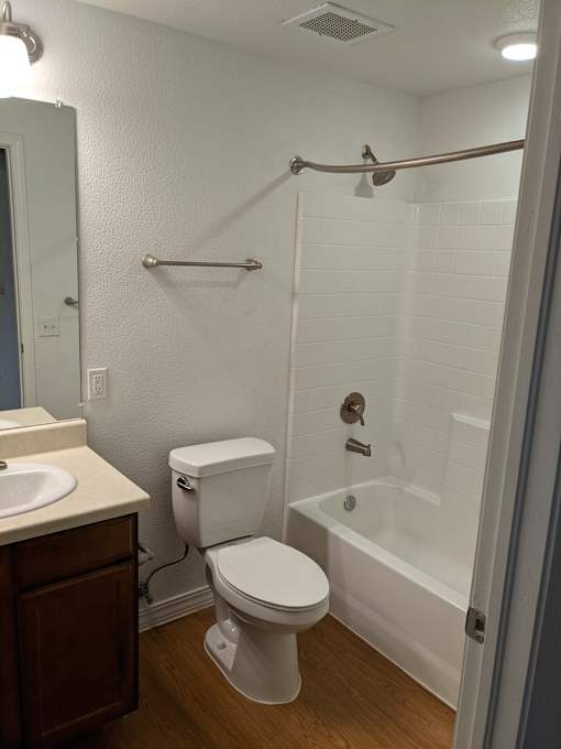 A white toilet is next to a white bathtub in a bathroom.