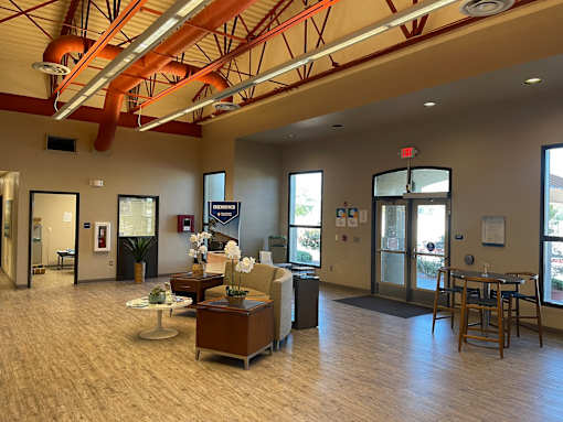 A spacious room with a dining table and chairs, a sofa, and a coffee table.