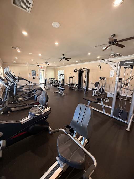 A gym with treadmills, weights, and exercise equipment.