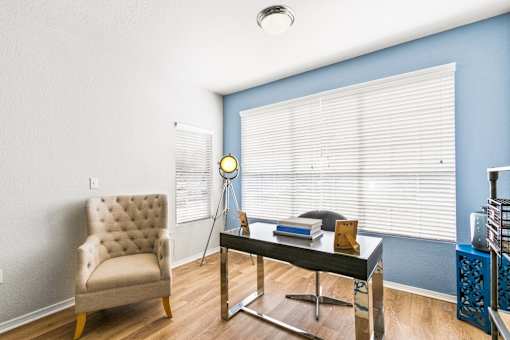 a living room with a chair and a glass desk