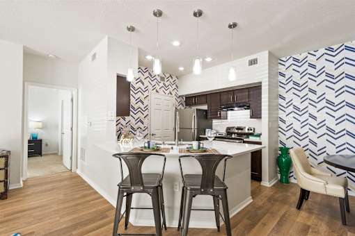 a view of a kitchen with a bar and stools