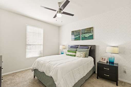 a bedroom with a bed and a ceiling fan