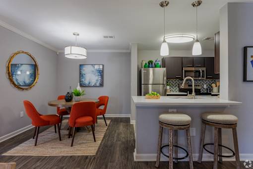 A kitchen with a dining table and chairs.