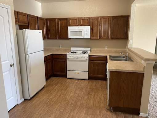 A kitchen with wooden cabinets and a white refrigerator.