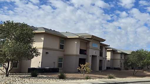 A row of houses with trees in front.