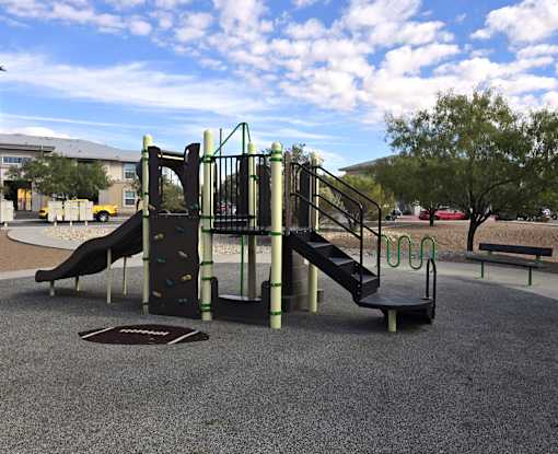 A playground with a slide and a climbing frame.