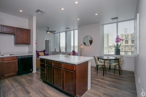 A kitchen with a white counter top and wooden cabinets.